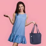 Women’s navy blue tote handbag with long shoulder straps and decorative tassel