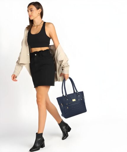 Women’s navy blue tote handbag with quilted front design and multiple zipper pockets