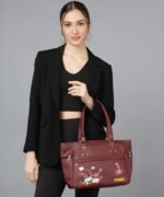 Women’s maroon tote handbag with floral embroidery and multiple zipper pockets