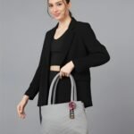 Women’s light grey tote handbag with wave pattern, shoulder strap and pom-pom charm