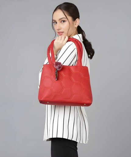 Woman carrying red honeycomb pattern tote handbag with shoulder strap